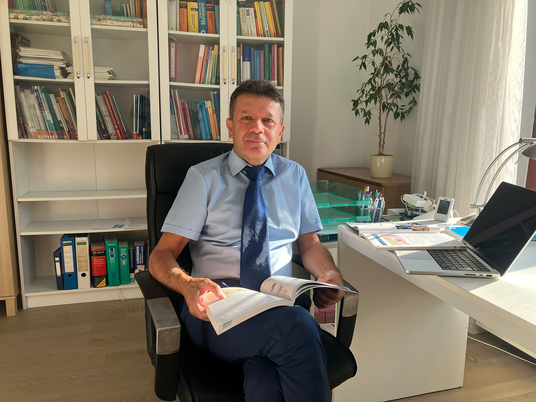 Lehrkraft im Arbeitszimmer beim Lesen